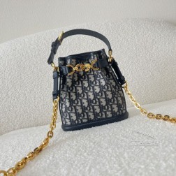 DIOR C'est 手袋。饰以蓝色 Oblique 印花,蓝色牛皮革细节提升格调。水桶包造型,设有 CD Lock 开合,饰以旋钮式字母 D,可安全收纳各种日常用品。小号款式,搭配顶部手柄和饰以皮革带的可调节、可拆卸的链条肩带,可手提,打造轻松舒适的造型。尺寸:17×7×18cm