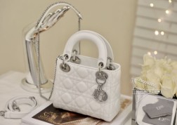 DIOR mini lady 白色羊皮银扣 系列手袋集中体现了品牌对典雅和美丽的深刻洞见。采用小羊皮革精心制作,以藤格纹缉面线打造醒目的绗缝细节,时髦典雅的设计经久不衰。饰以标志性的饰面金属吊饰,为精美的轮廓增添一分灵动。这款迷你Lady 手袋搭配可拆卸的链条肩带,可手提、肩背或斜挎,是晚装的理想伴侣。·可拆卸链条肩带·内部拉链口袋·可随心搭配其他刺绣肩带内含防尘袋尺寸: 17157cm#  三格白色羊皮