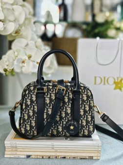 DIOR 新款蓝色提花保龄球款这款 D-Vibe 保龄球包是二零二四秋季成衣系列新品款式简约时尚。采用蓝色 Oblique 印花面料精心制作点缀以同色调皮革细节搭配别具一格的皮革钥匙包镌刻以 Christian Dior Paris 标志并点缀以金色饰面金属星星。随挂钥匙可打开拉链挂锁宽敞的隔层设有一个插袋和一个拉链口袋,可收纳各种日常用品。中号款式,实用设计搭配皮革顶部手柄和可调节、可拆卸的皮革肩带,可手提、肩背或斜挎。拉链开合,搭配镌刻以 Christian Dior Paris 标志的挂锁