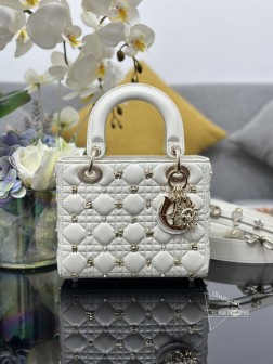 迪奥 Lady Dior My 四格星座钉白色内里配羊筋，配三枚徽章。采用羊皮革精心制作饰以藤格纹图案点缀以金色调树脂珠饰和金色饰面星座标志铆钉。饰以浅金色饰面金属 D.I.O.R. 吊饰为精美的轮廓增添一分灵动。小号款式，设计别致肩带可饰以徽章彰显个性可手提或斜挎。尺寸：20 x 16.5 x 8厘米，型号 M