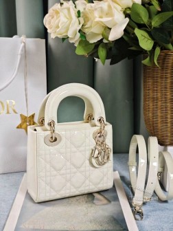 DIOR mini lady三格奶昔白色漆皮系列手袋集中体现了品牌对典雅和美丽的深刻洞见。采用黑色漆皮牛皮革精心制作，以藤格纹缉面线打造醒目的绗缝细节，时髦典雅的设计经久不衰。饰以标志性的浅金色饰面金属吊饰，为精美的轮廓增添一分灵动。这款迷你Lady 手袋搭配可拆卸的链条肩带，可手提、肩背或斜挎，是晚装的理想伴侣。·可拆卸链条肩带·内部拉链口袋·可随心搭配其他刺绣肩带内含防尘袋尺寸： 17157cm#  三格奶昔白漆皮